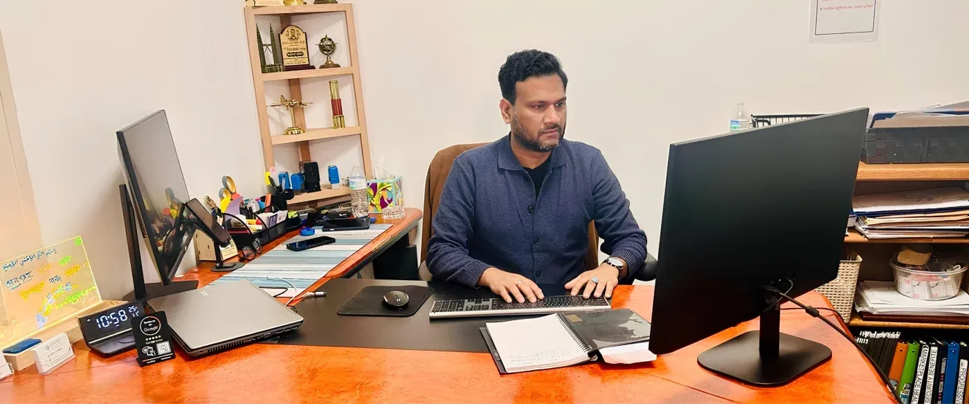 Hosen Chowdhury working at his desk in the Detroit office
